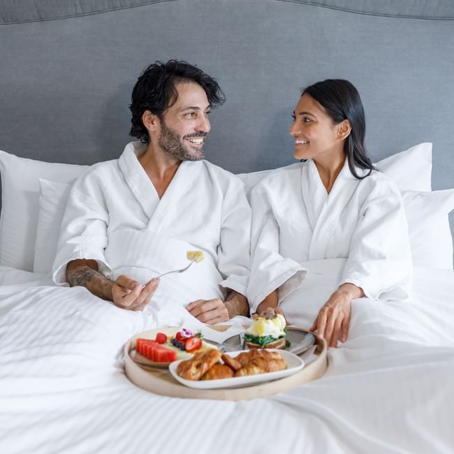 Couple having breakfast on the bed in a room at Pullman Sydney Hyde Park