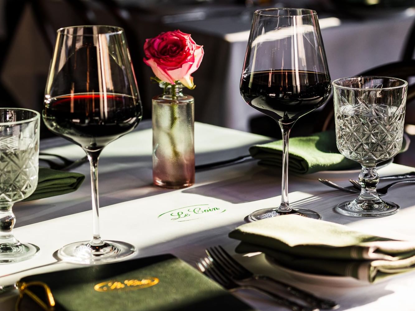 Dining table with two glasses of wine and menu book