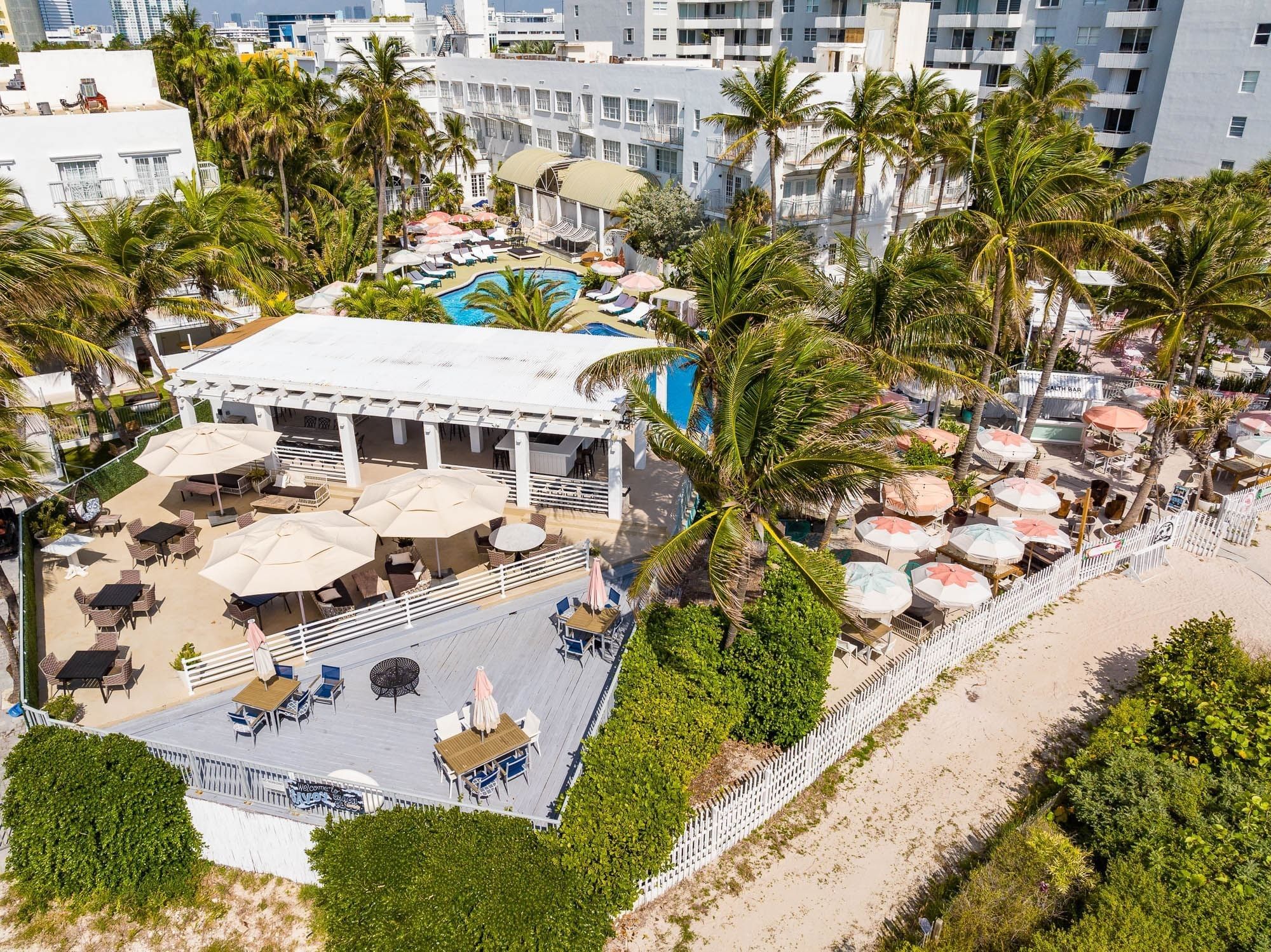 Aerial view of the hotel's grounds, showing the pool, beach, and outdoor furniture.