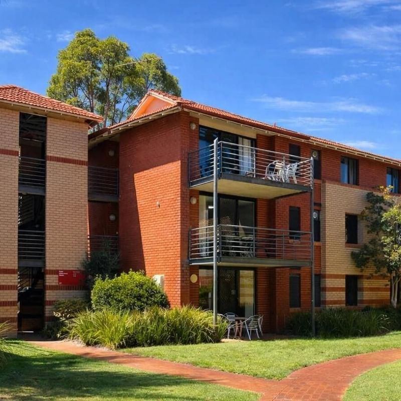 Exterior view of UniLodge at Curtin University Erica Underwood House with balconies and greenery.