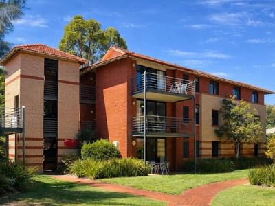 Exterior view of UniLodge at Curtin University Erica Underwood House with balconies and greenery.