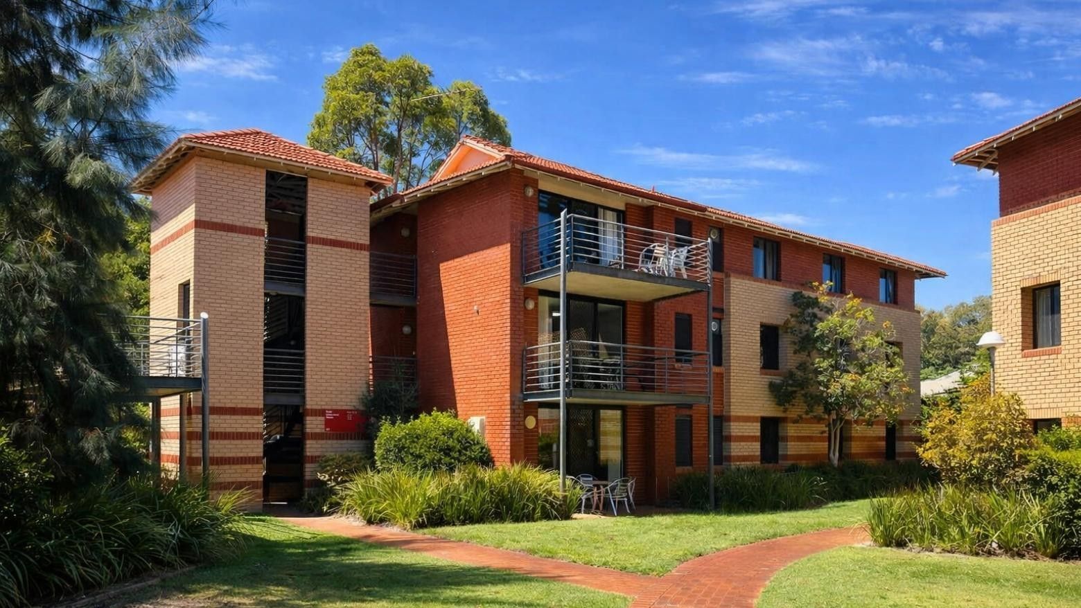 Exterior view of UniLodge at Curtin University Erica Underwood House with balconies and greenery.