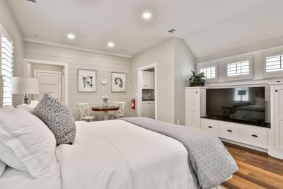 Modern Deluxe King Cottage with a cozy bed, dining table, TV unit, and neutral decor by Cottages at Laurel Brooke