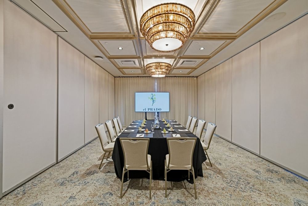 meeting room set up at el PRADO that is intimate and features a screen projection at the end of the table