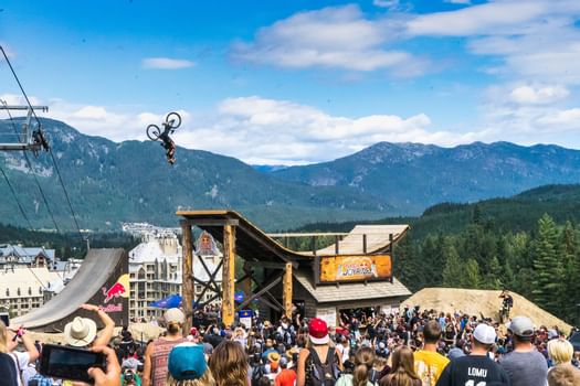 BMXer doing backflip off ramp with mountains in background