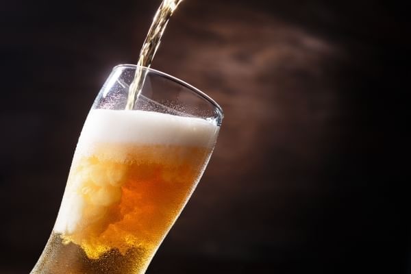 A stream of beer pouring into a pint glass.