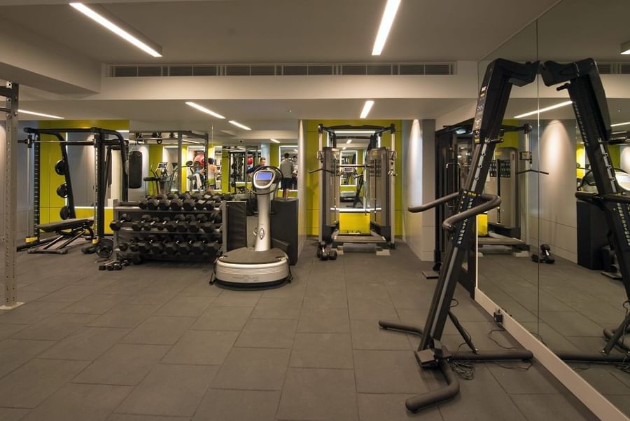 A gym with mirrors and equipment at The May Fair Hotel
