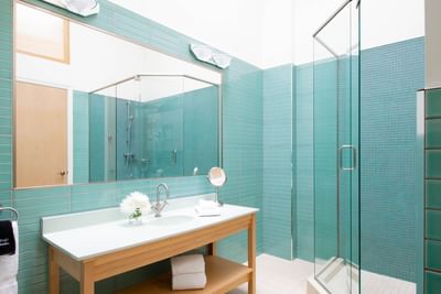 Bathroom vanity, large mirror & shower area with glass cubicle in King Premiere Sky at Retro Suites Hotel