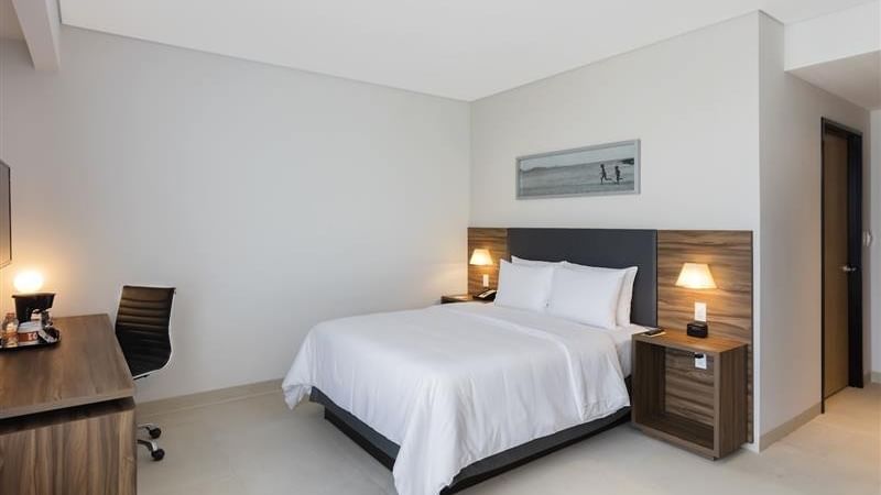 Guest room with wooden nightstands by the bed at Fiesta Inn Express Cancún Cumbres, accommodations in cancun