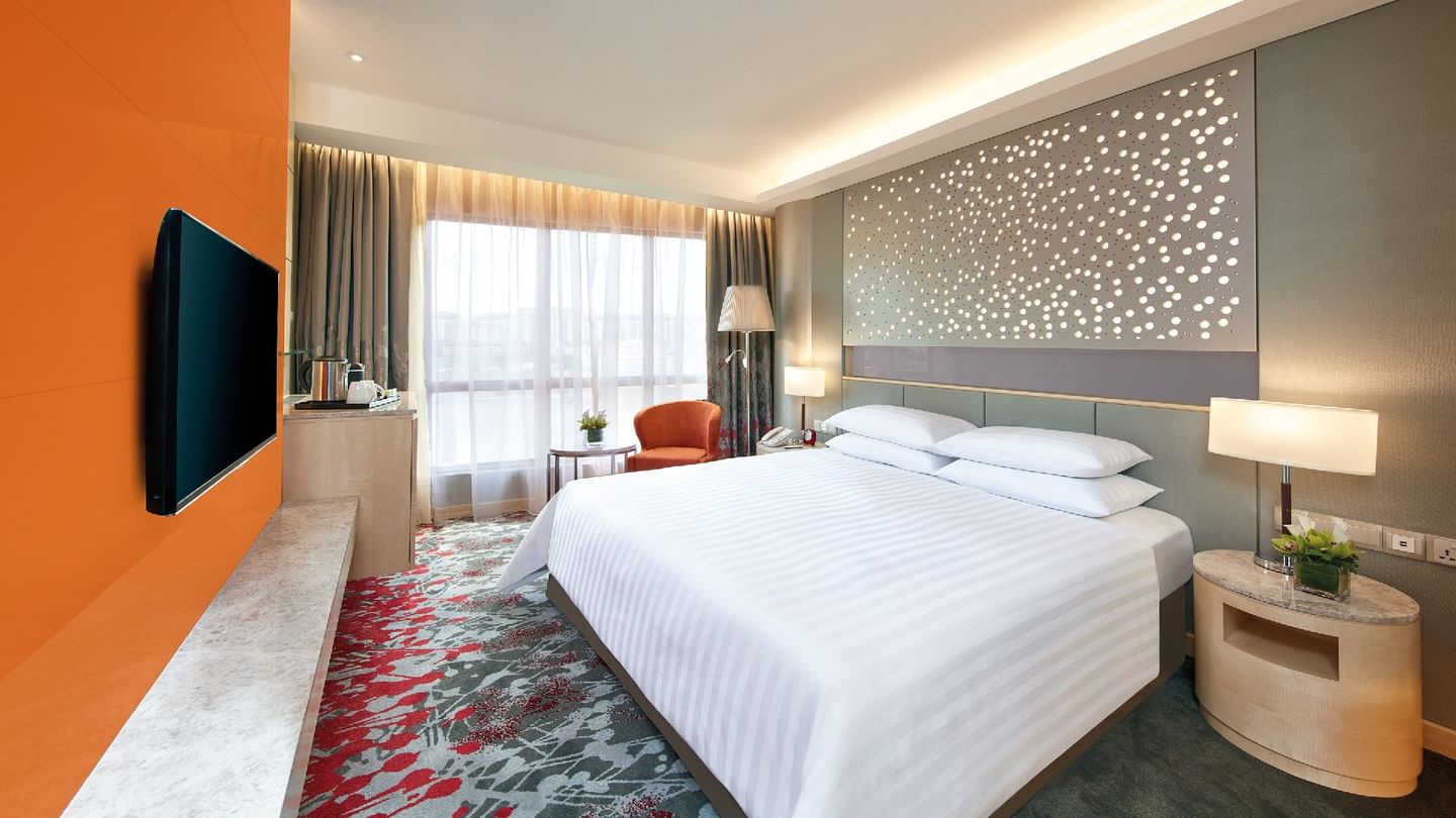 A modern Deluxe King Room at Sunway Hotel Pyramid, featuring a king bed, vibrant carpet, and city views