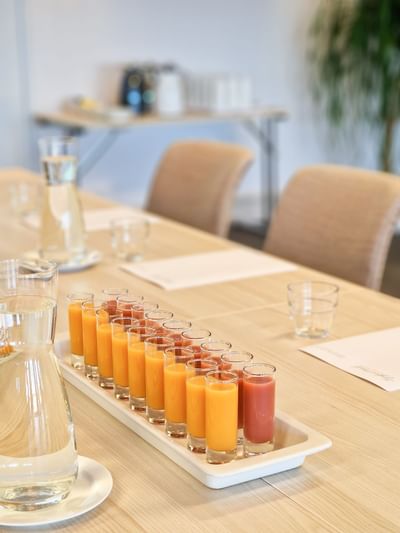 Close-up of colorful juice shots and water glasses on a conference table set for a business meeting at Tyrifjord Hotel