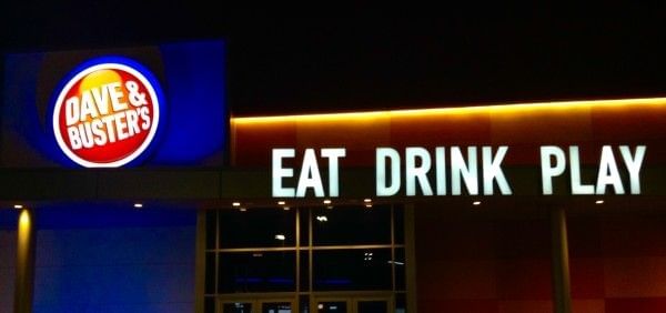 A glowing Dave & Buster's sign at nighttime.