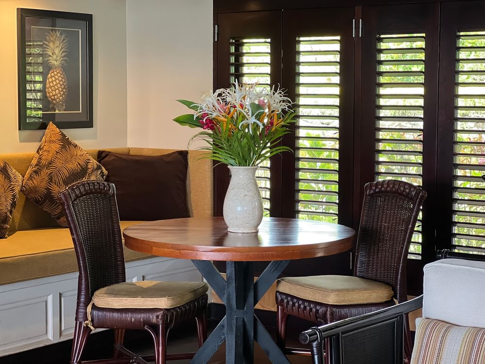 A cozy dining area with tropical decor and wooden table at Warwick Le Lagon - Vanuatu, Efate.