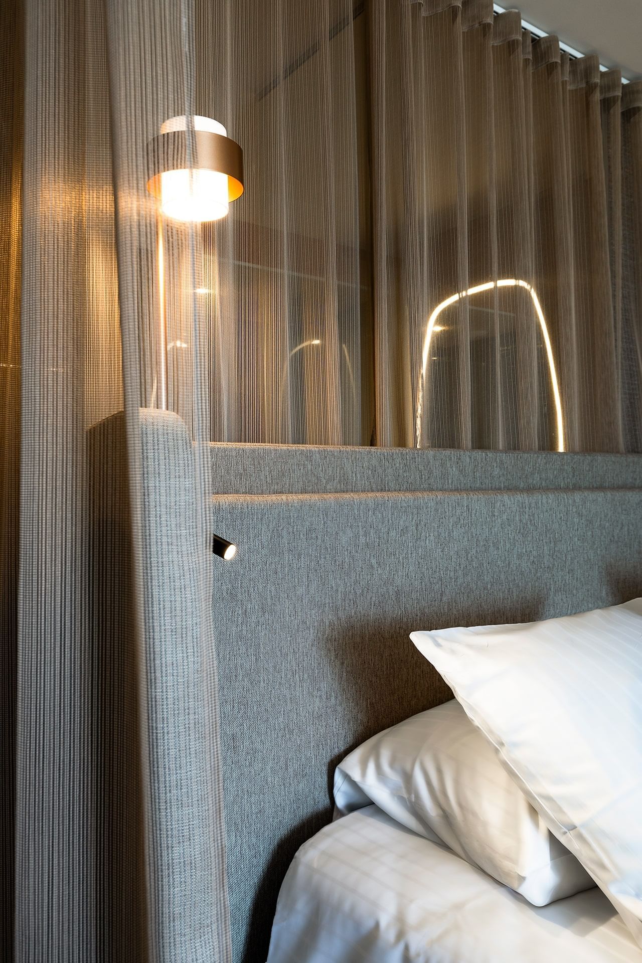 Gros plan d'un appuie-tête avec une lampe de chevet dans une chambre à l'Oceania Saint-Malo