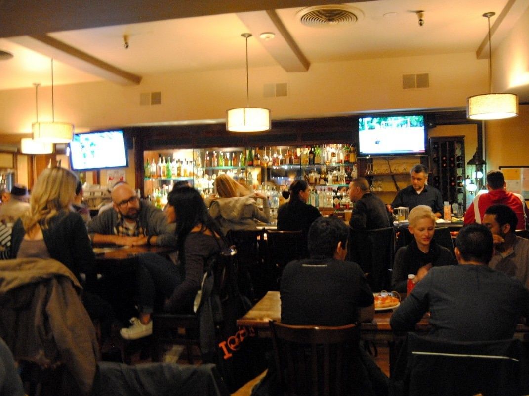 Customers enjoying drinks and food at a busy Pickwick San Francisco bar.