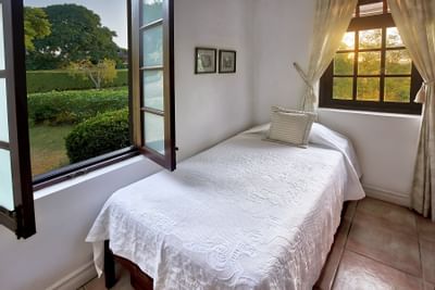 bed in room with windows in tropical setting