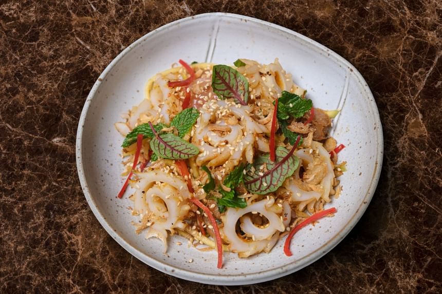 Fresh seafood salad with spiral cut squid, red peppers, mint leaves, and crispy shallots in Square One at Park Hyatt Saigon