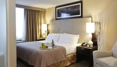 a tray with drinks sitting on a hotel bed