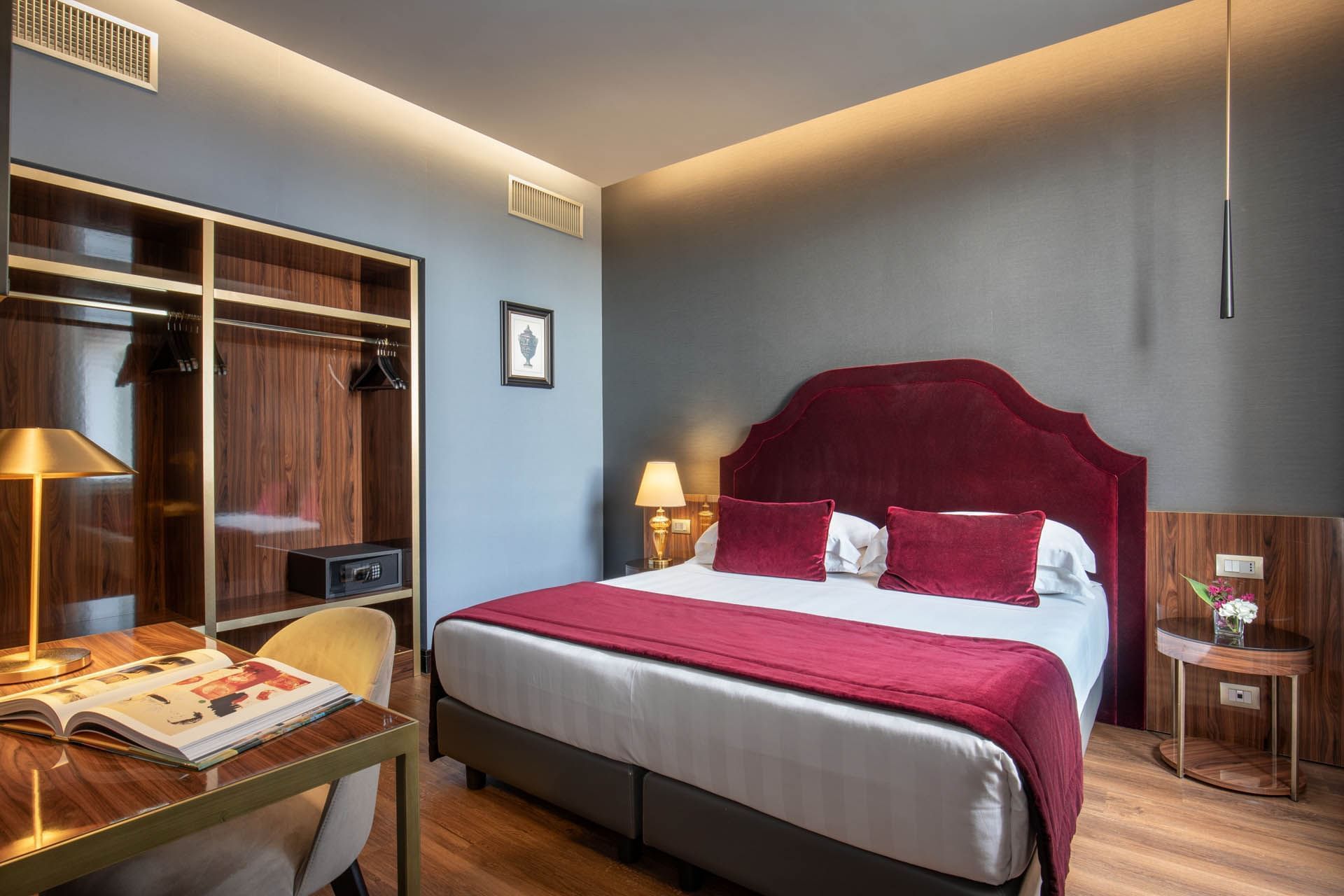 Modern Guardian Suite at The Guardian Hotel with a king bed, burgundy accents, desk, wardrobe, and soft lighting
