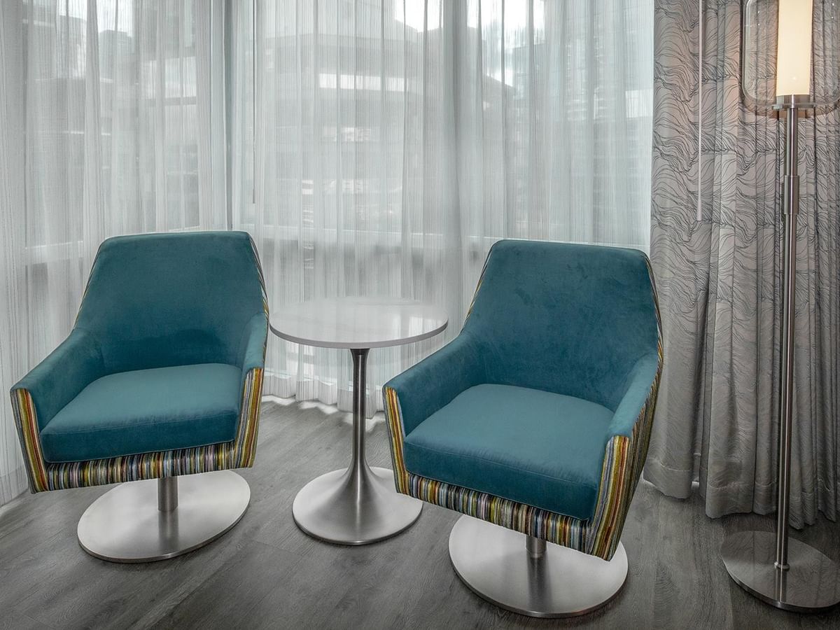 Two chairs and a table in a hotel room.