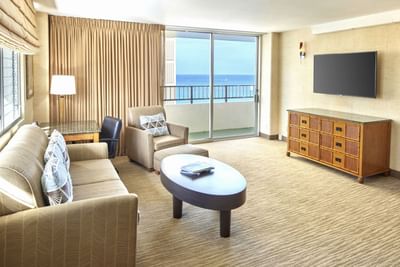 Living space with cozy loungers, work desk & a TV in Two Bedroom Penthouse Suite at Waikiki Resort Hotel by Sono