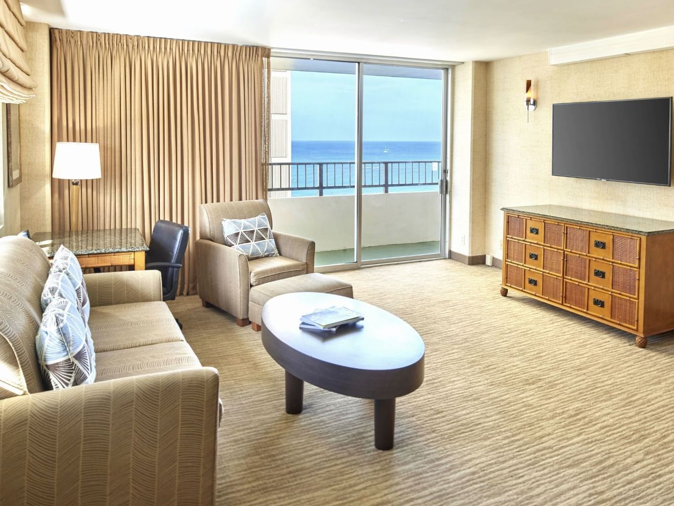 Living space with cozy loungers, work desk & a TV in Two Bedroom Penthouse Suite at Waikiki Resort Hotel