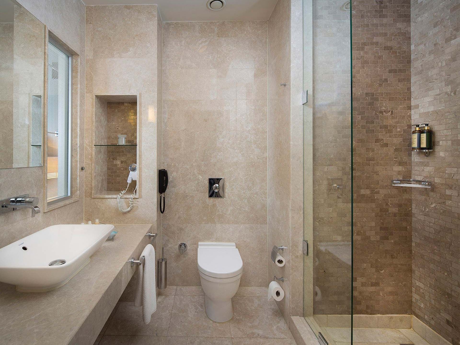 Titanic Business Kartal’daki Superior Oda’da, duş alanı, klozet ve lavabo ünitesine sahip şık bir banyo tezgahı bulunmaktadır.