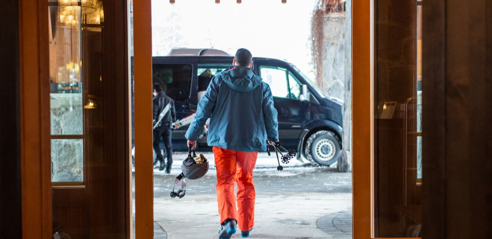Man with ski gear by the entrance at Nita Lake Lodge