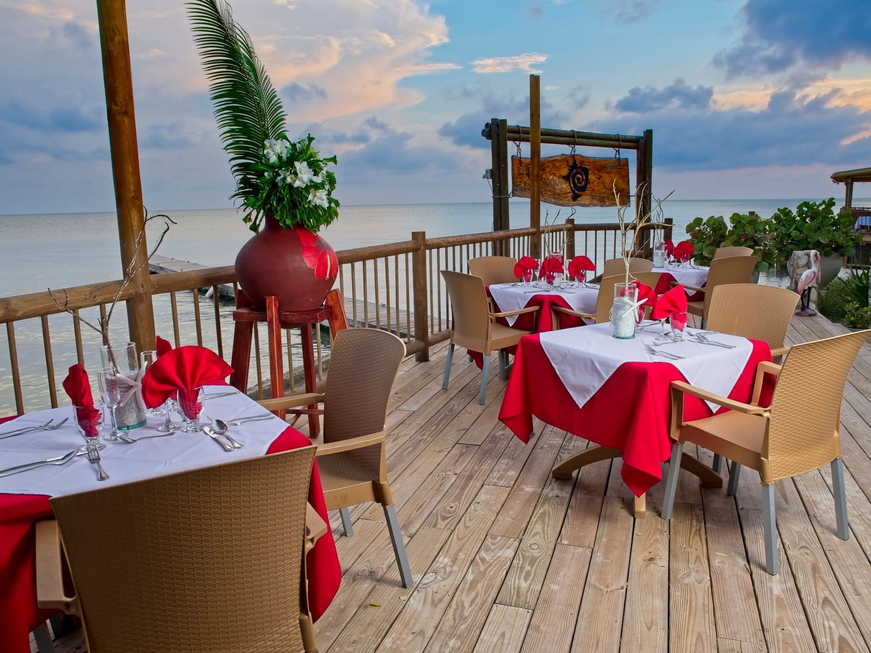 Wooden deck with dining tables by ocean in Chipi-Chipi Terrace at Hotel Isla Del Encanto