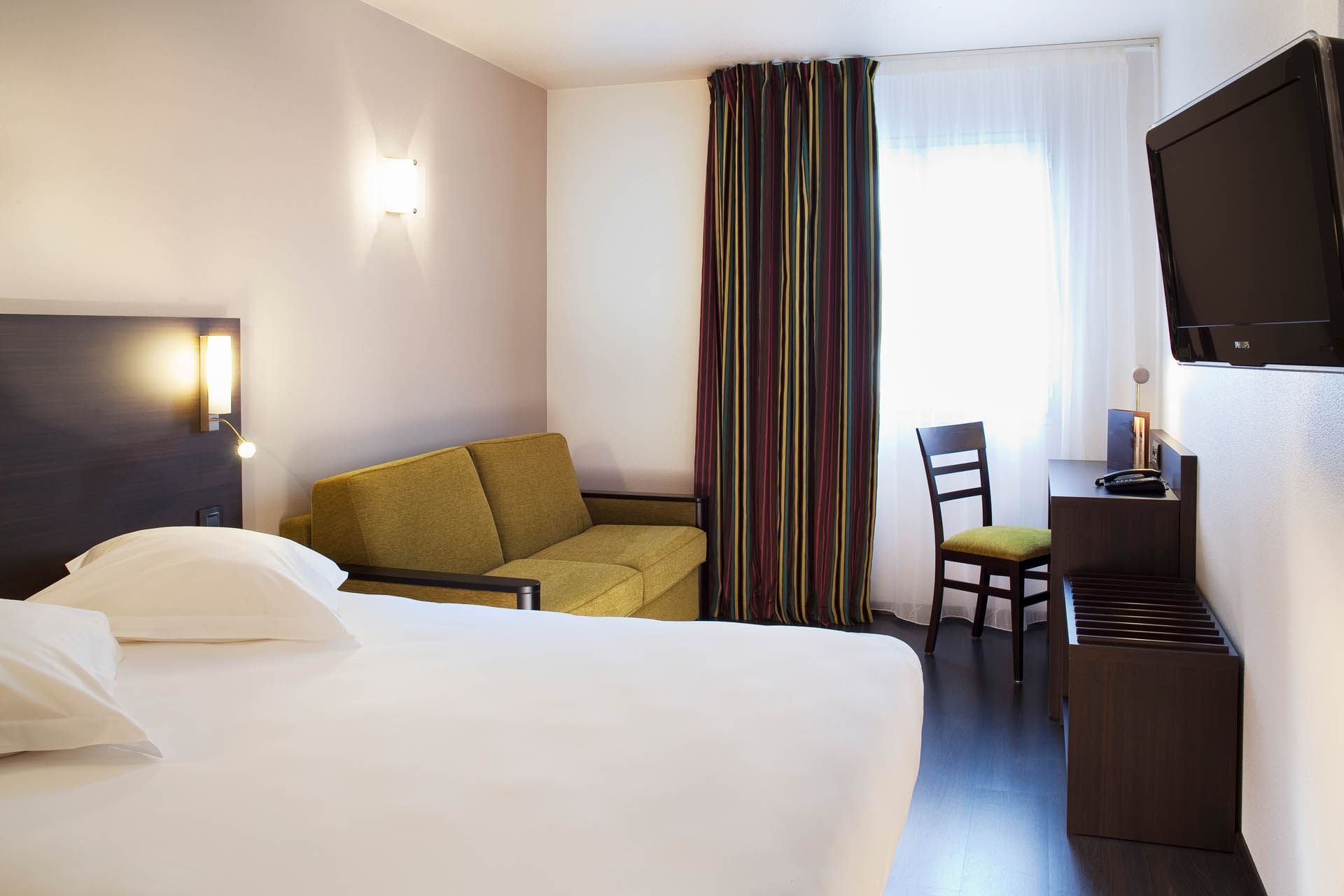 Lit king-size et salon dans une chambre familiale à l'Escale Oceania Vannes