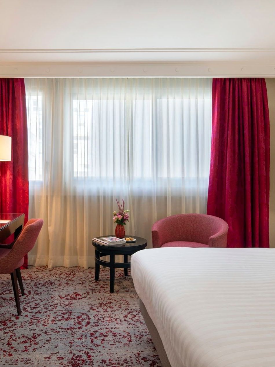 Workspace with a desk by an armchair surrounding a small coffee table in Superior Room at Warwick Paris Champs Elysées