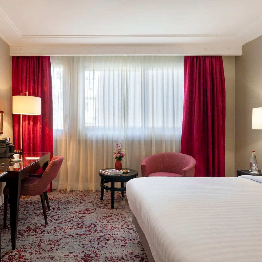 Chambre Supérieure élégamment meublée, dotée d'un lit confortable, d'une décoration raffinée et d'équipements modernes, au Warwick Champs-Élysées Paris.