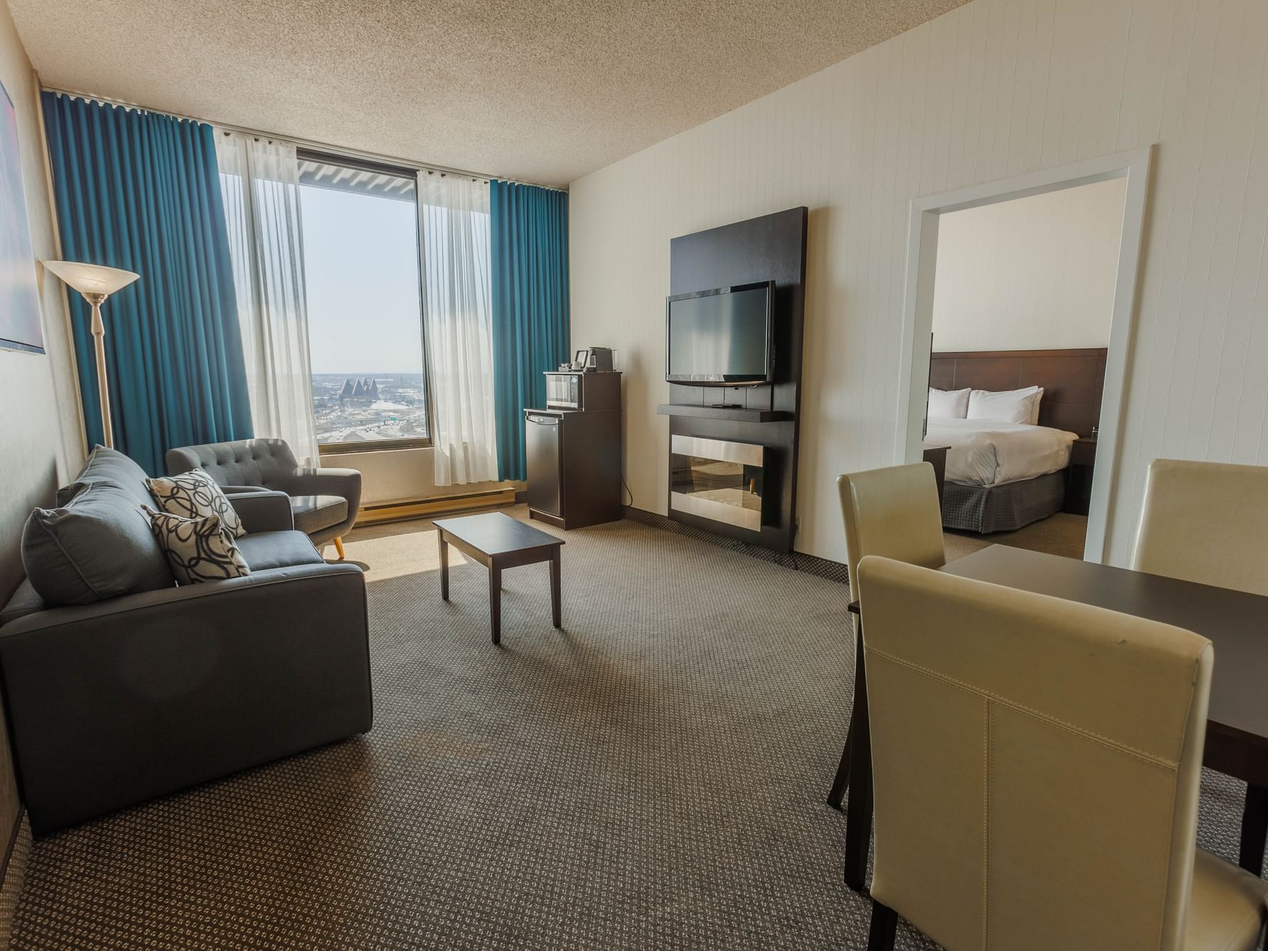 TV lobby area with window view in Executive King Suite at Travelodge Hotel & Convention Center Québec City