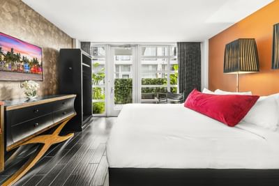 King bed with a nightstand in Garden Deluxe King at Fairwind Hotel Miami