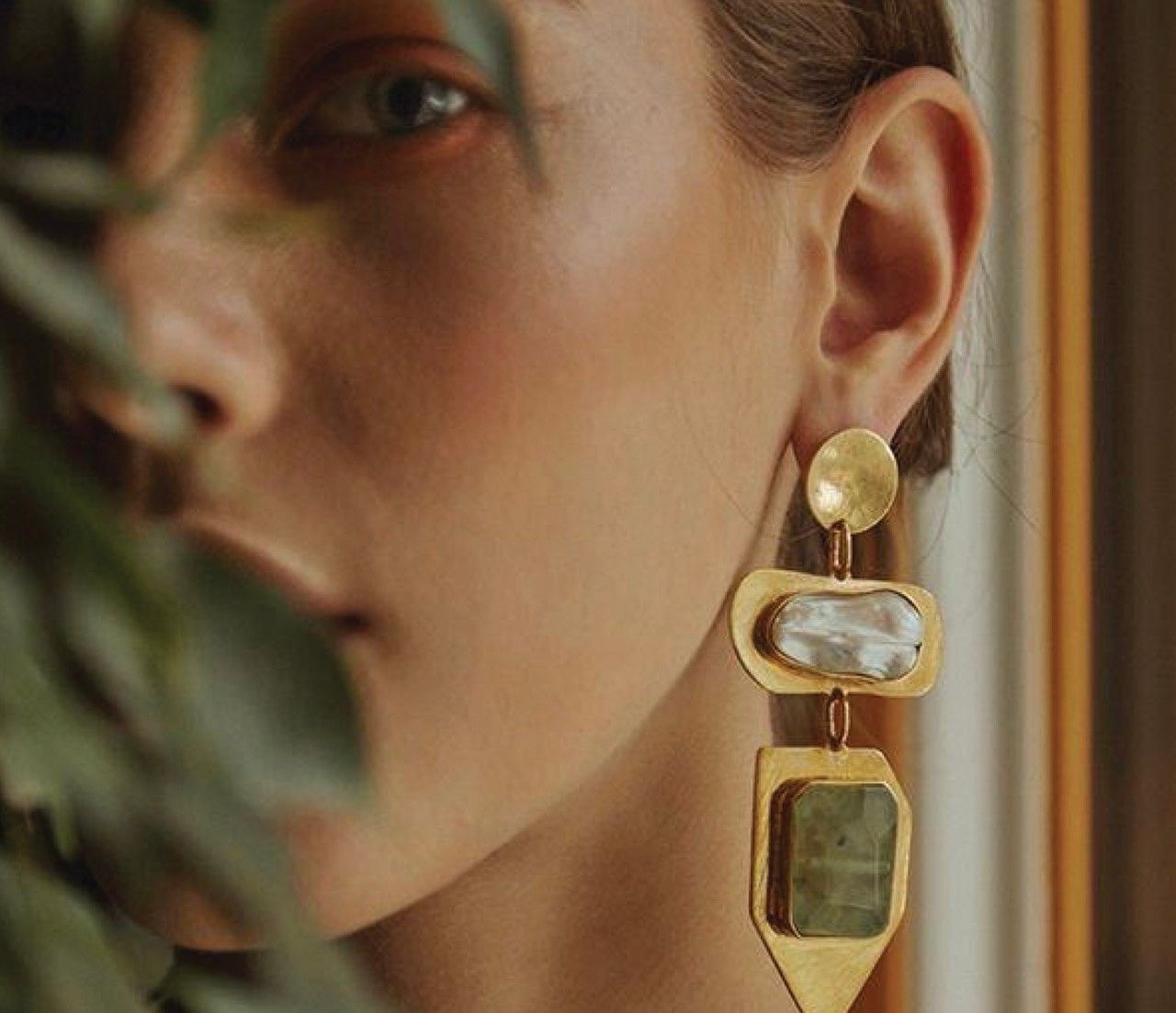 Guest at Elysium Manly peering through green foliage, wearing a pearl earring, featuring Manly hotel photos