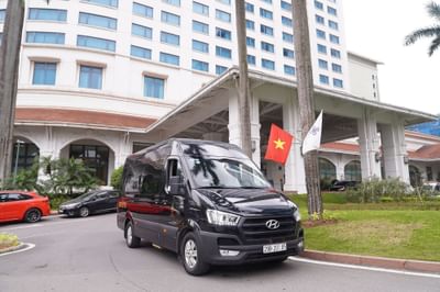 A black van parked in front of a Hanoi Daewoo Hotel