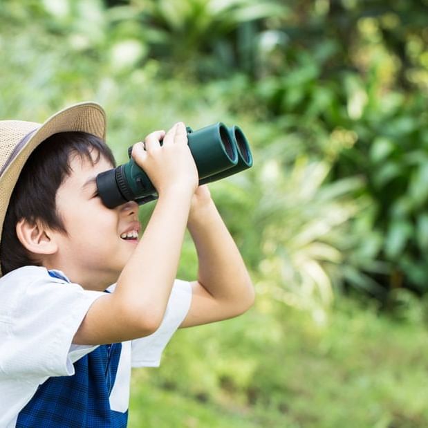 Closeup of a boy zooming through telescope at Amara Hotels