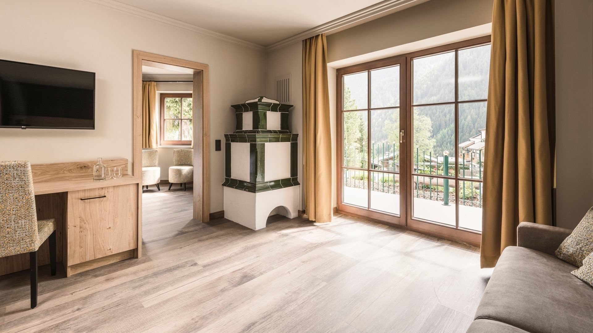 Junior Garden Suite moderna con pavimenti in legno e vista sulla montagna al Falkensteiner Hotel Falkensteinerhof, Valles.