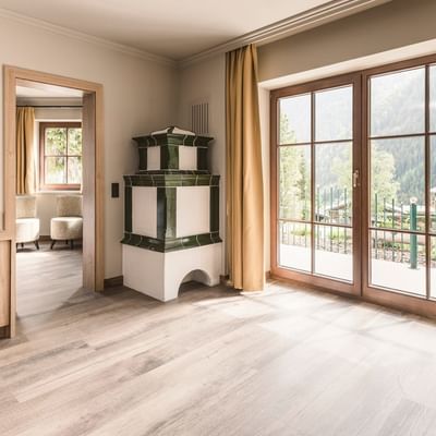 Junior Garden Suite moderna con pavimenti in legno e vista sulla montagna al Falkensteiner Hotel Falkensteinerhof, Valles.