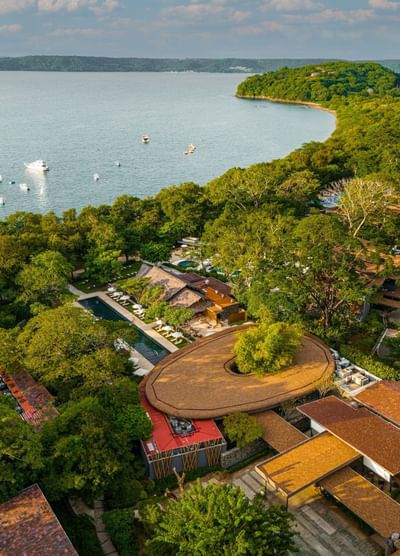 Aerial view of El Mangroove Hotel by a forested coastline with boats in the water