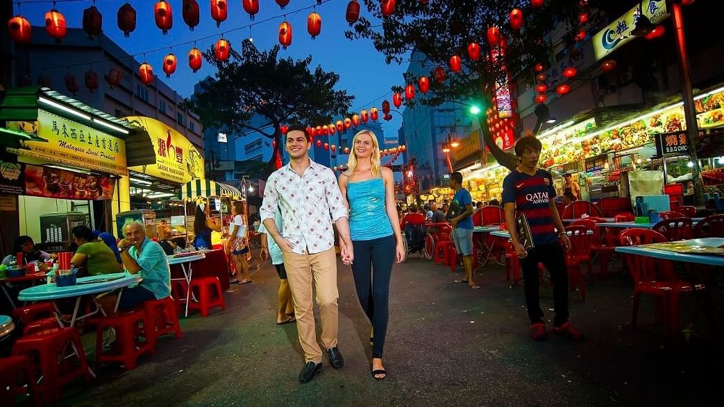 Couple walking on a street with food stalls near Sunway Lagoon