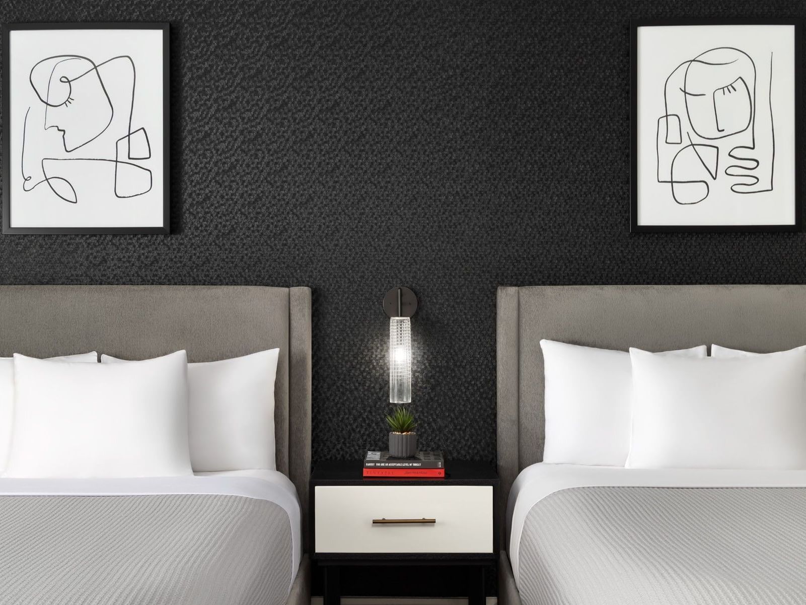 Modern accessible double room with two beds, abstract artwork, and shared nightstand at ArtHouse Hotel New York City