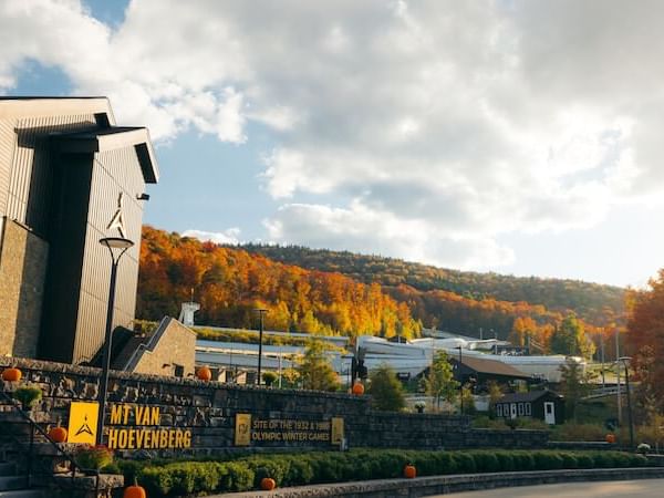 The sign for Mt Van Hoevenberg Olympic site with autumn foliage in the background near Lake Placid Club Grandview