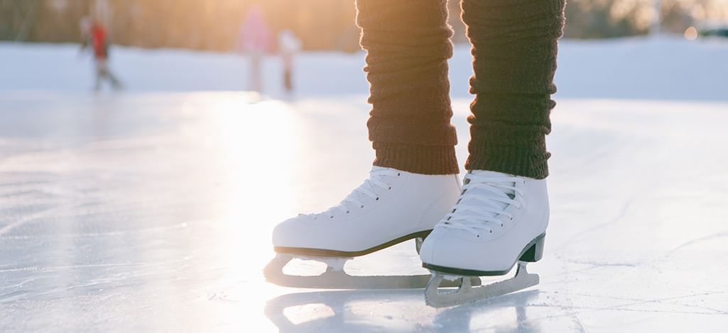 A pair of white ice skates resting on the ice