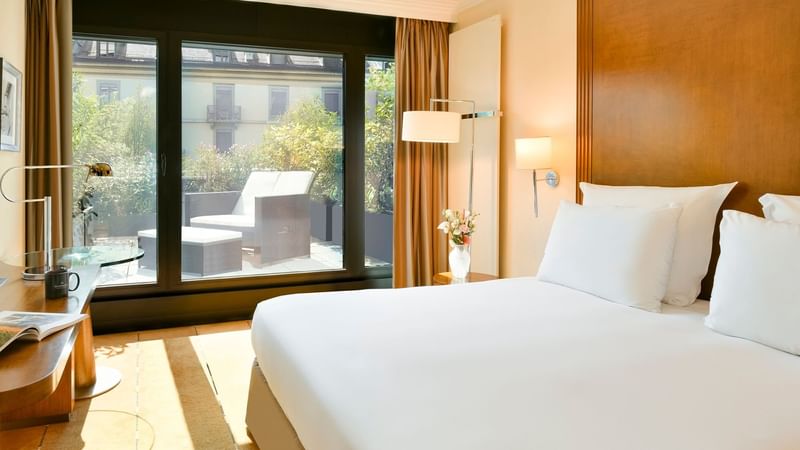 Bed & balcony lounge area in Classic Terrace Room at Warwick Geneva