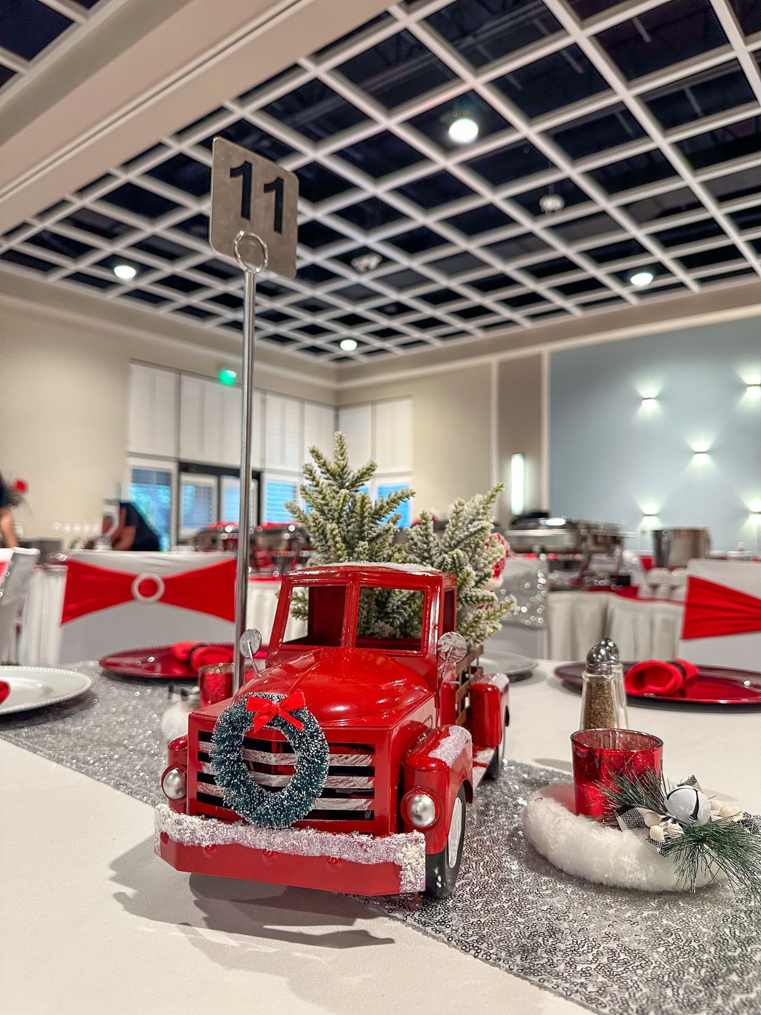 A red toy truck with a wreath and Christmas tree as a centerpiece decoration at the Christmas buffet at Rosen Inn Lake Buena Vista.