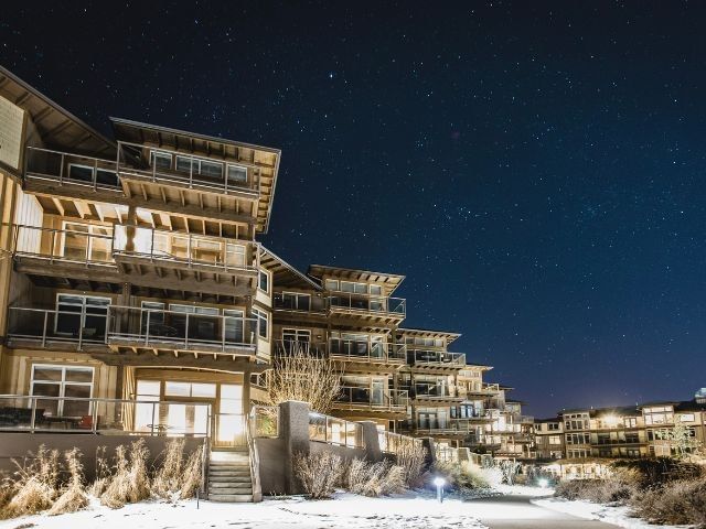 The Cove Lakeside Resort illuminated at night with snow-covered grounds beneath a starry winter sky.