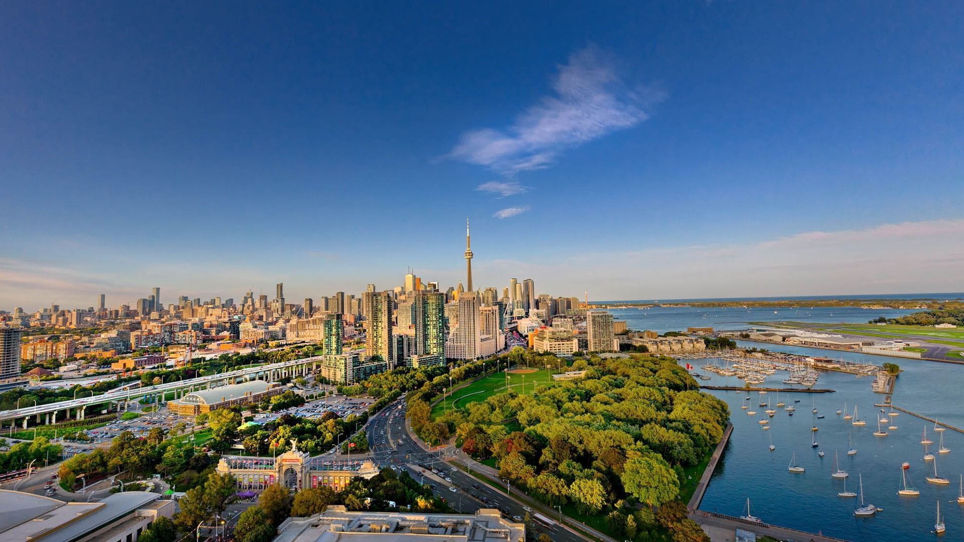 Aerial skyline view with CN Tower and waterfront marina facing green parklands and city buildings at Hotel X Toronto