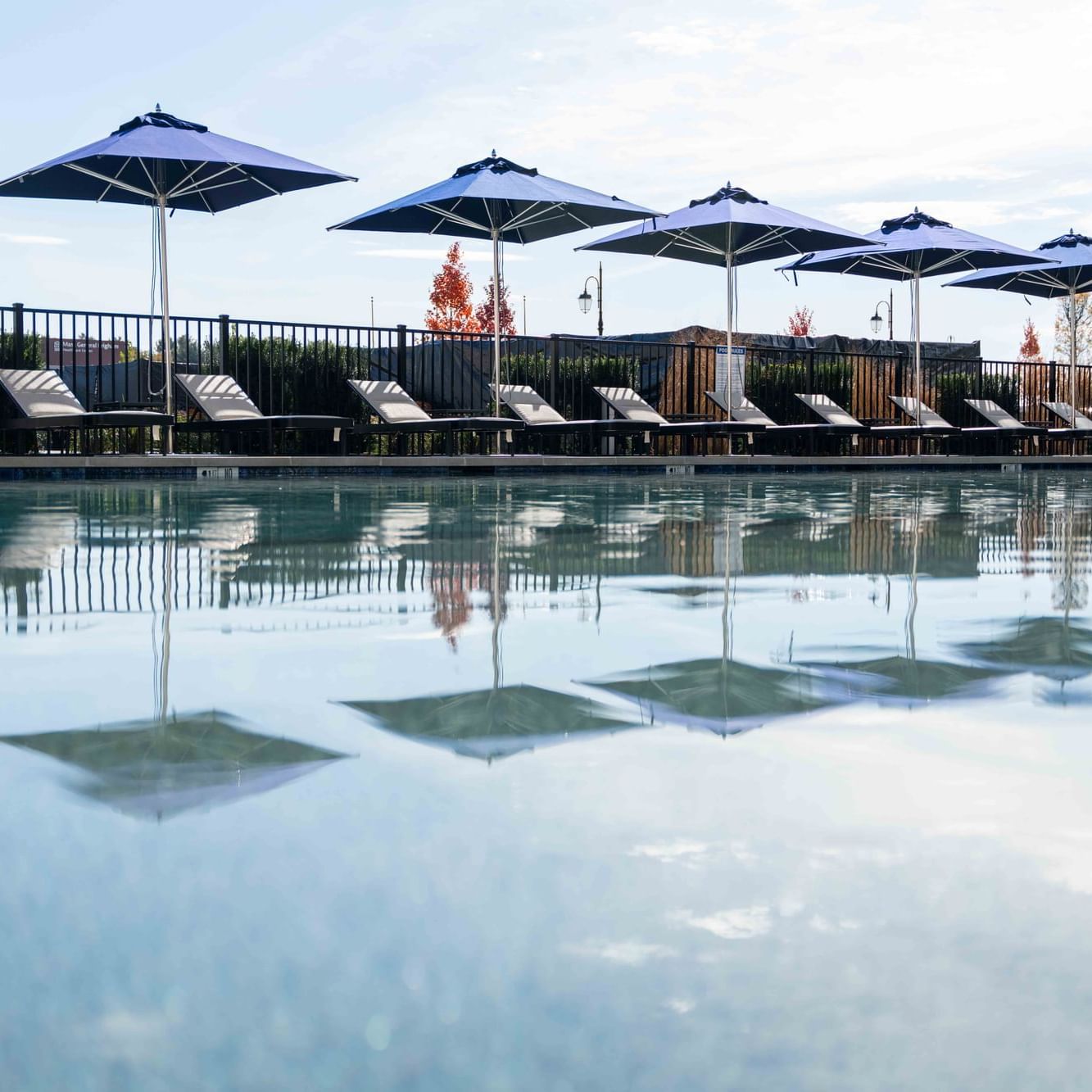 Sunbeds & umbrellas by the outdoor pool area at The Artisan Hotel at Tuscan Village