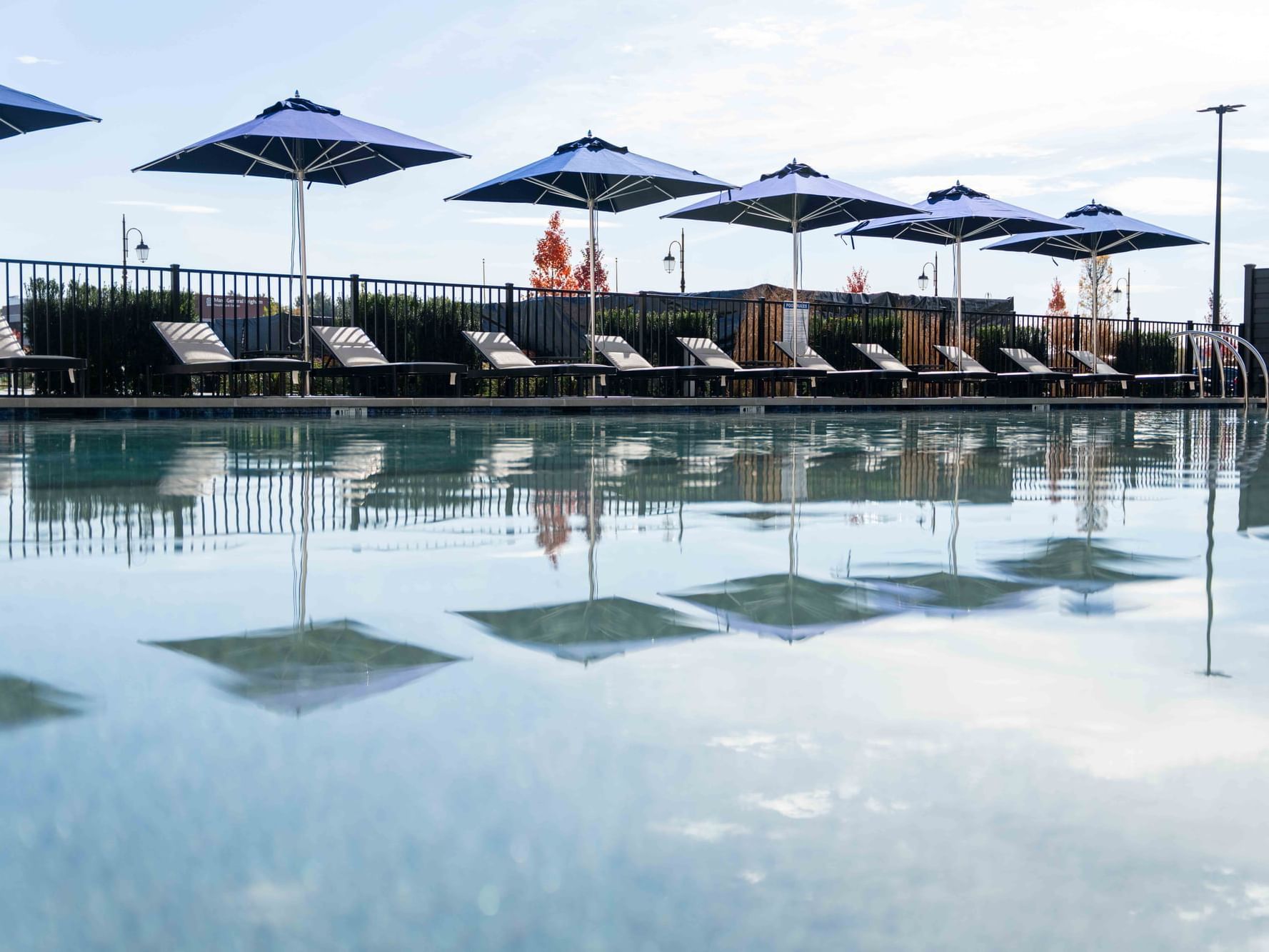 Sunbeds & umbrellas by the outdoor pool area at The Artisan Hotel at Tuscan Village